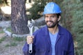 Worker with blue protective hat holding adjustable wrench Royalty Free Stock Photo