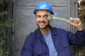 Worker with blue protective hat holding adjustable wrench Royalty Free Stock Photo