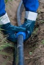 Worker in blue uniform laying water pipes and an electrician in a trench Royalty Free Stock Photo