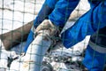 Worker in blue uniform repairs and insulates the pipe. old rusty pipe leaks.