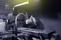 The worker in blue workwear, the operator of the CNC machine, oversees the process and controls it. A man works in a factory with Royalty Free Stock Photo