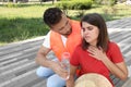 Worker with bottle of water helping woman on city street. Suffering from stroke Royalty Free Stock Photo