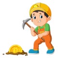 The worker boy is mining bitcoin with pickaxe in the ground Royalty Free Stock Photo