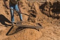 Worker of a brick factory strains sand with a  in a wheelbarrow, for the elaboration of bricks Royalty Free Stock Photo