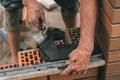 Worker or bricklayer works with trowel laying bricks. Builder makes brickwork on construction site, close up on hands Royalty Free Stock Photo