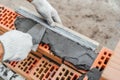 Worker or bricklayer works with trowel laying bricks. Builder makes brickwork on construction site, close up on hands Royalty Free Stock Photo