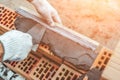 Worker or bricklayer works with trowel laying bricks. Builder makes brickwork on construction site, close up on hands Royalty Free Stock Photo