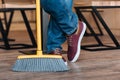 Worker with broom in cafe