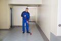 Worker With Broom Cleaning Office Corridor