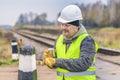 Worker with brush and paint on the railway