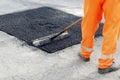 Worker brushing tarmac