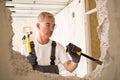 Worker builder demolish wall with tool Royalty Free Stock Photo