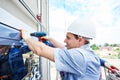 Worker builder installing glass windows on facade Royalty Free Stock Photo