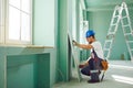 Worker builder installs plasterboard drywall at a construction Royalty Free Stock Photo