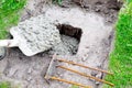 Worker builder man pour in cement solution with rubble, slurry, concrete mortar in pit or hole with shovel. Preparing Royalty Free Stock Photo