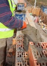 Worker building brick walls at house construction site, bricklayer and cement. Royalty Free Stock Photo