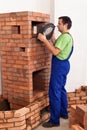 Worker building a masonry heater - trying on an iron and glass d Royalty Free Stock Photo