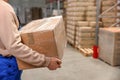 Worker with cardboard box in warehouse, closeup. Wholesaling