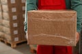 Worker with cardboard box in warehouse, closeup. Wholesaling