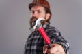 Worker, Carpenter or builder in hard hat with hammer. Selective focus. Bearded man in helmet hammering nail.