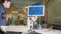 Worker carpenter handles wooden panels on the edging machine on the furniture factory