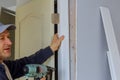 Worker carpenter at internal door installation with using nail gun