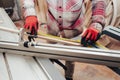 Worker in a carpentry shop measures plywood for cutting Royalty Free Stock Photo