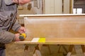 Carpenter uses hand drill, acu power tool and tightens the screws on the wooden door frame