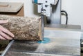 Worker in the carpentry workshop cuts the log into boards using a band saw. Joinery. Raw wood Wooden crafts. Work at the factory Royalty Free Stock Photo