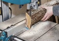 Worker in the carpentry workshop cuts the log into boards using a band saw. Joinery. Raw wood Wooden crafts. Work at the factory