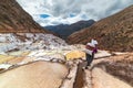 Worker carrying a big sack of salt, on the terraced salt pans in Maras, Urubamba Valley, Peru. Manual work in developing countries