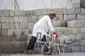 A worker carrying blocks for making a house