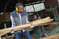 Worker carrying lengths wood Royalty Free Stock Photo