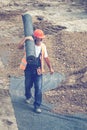 Worker carrying rolls of geotextile insulation 3