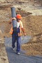 Worker carrying rolls of geotextile insulation 5