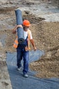 Worker carrying rolls of geotextile insulation