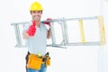 Worker carrying step ladder while showing thumbs up Royalty Free Stock Photo
