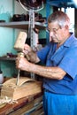 Worker carving wood with a chisel and hammer Royalty Free Stock Photo