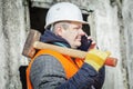 Worker with cell phone and sledge hammer near building Royalty Free Stock Photo