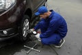 Worker checking tire pressure in car wheel at station Royalty Free Stock Photo