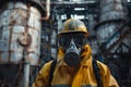 A worker in a yellow protective suit and gas mask checks for a chemical leak at a chemical factory