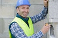 worker checks erected brick wall with level