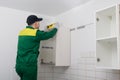 A worker checks the evenness of the installation of the upper cabinet of the kitchen set