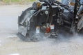 Worker checks the progress of the Milling of asphalt for road reconstruction accessory for skid steer