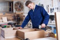 Worker chiseling plank at workshop