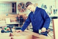 Worker chiseling plank at workshop