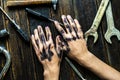 Worker class person dirty dark hands on the wooden table with tools equipment f