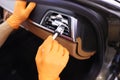 Worker cleaning automobile air conditioner vent grill with brush closeup