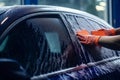 Worker cleaning automobile windshield foam wash. Generate Ai