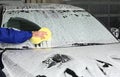 Worker cleaning automobile windshield with sponge at professional car wash